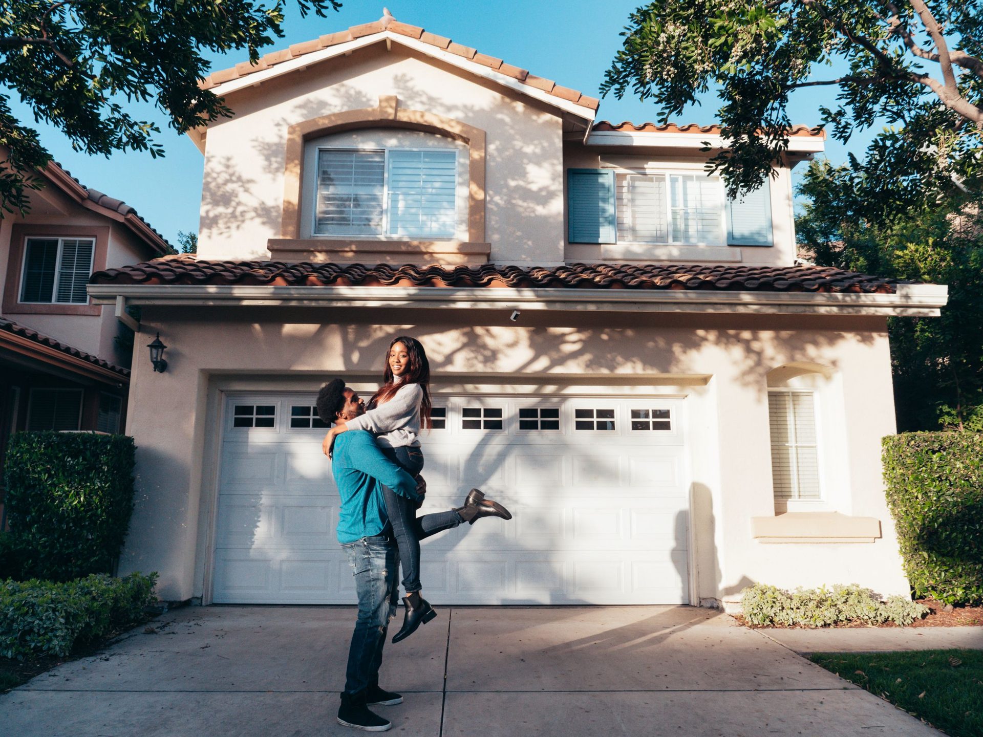 Happy home buyers celebrating in front of their new house