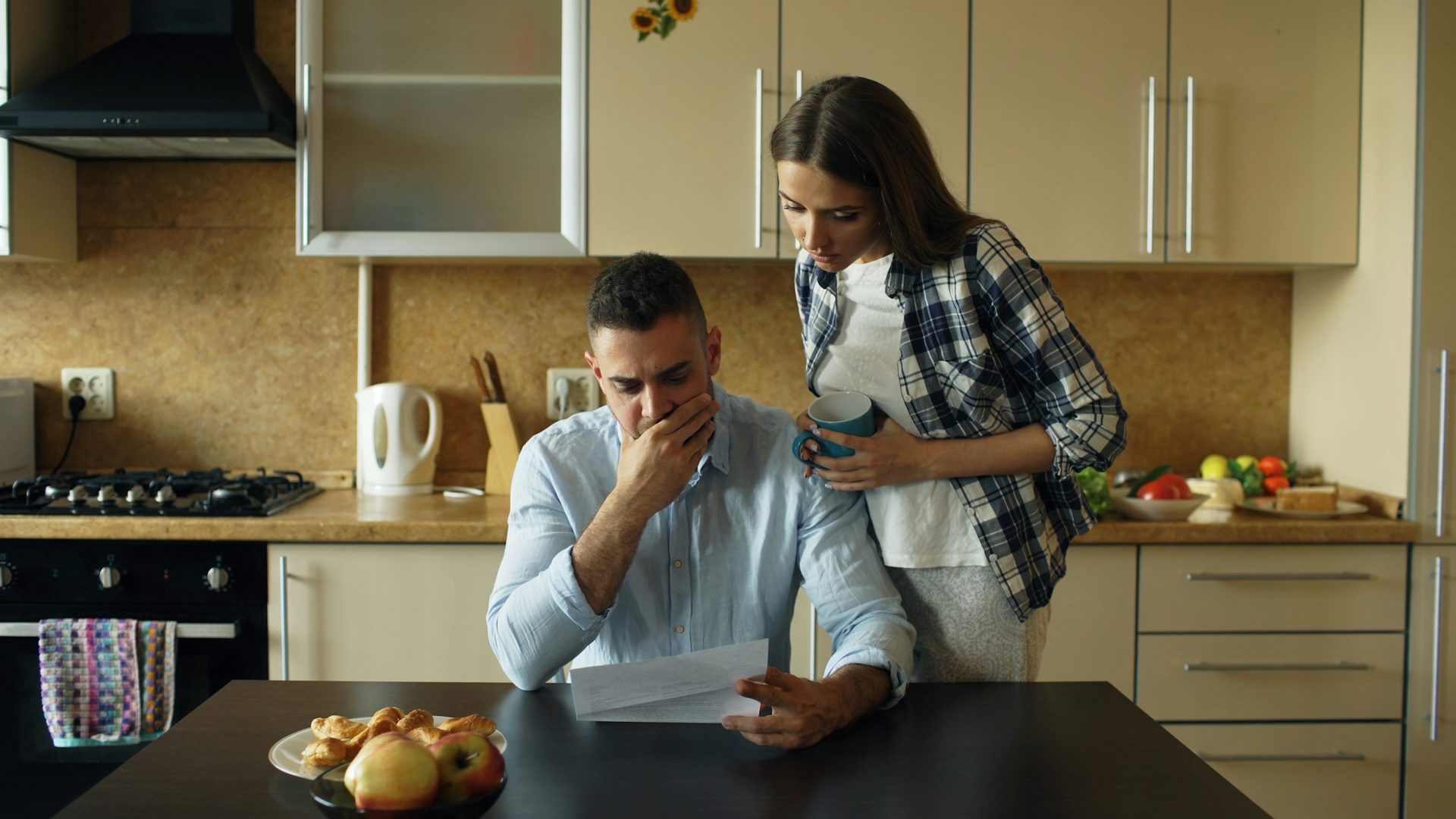 Homeowners reviewing a mortgage letter at their kitchen table